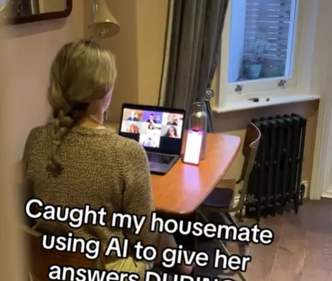A lady doing a job interview at home, with a mobile app open next to her laptop screen.